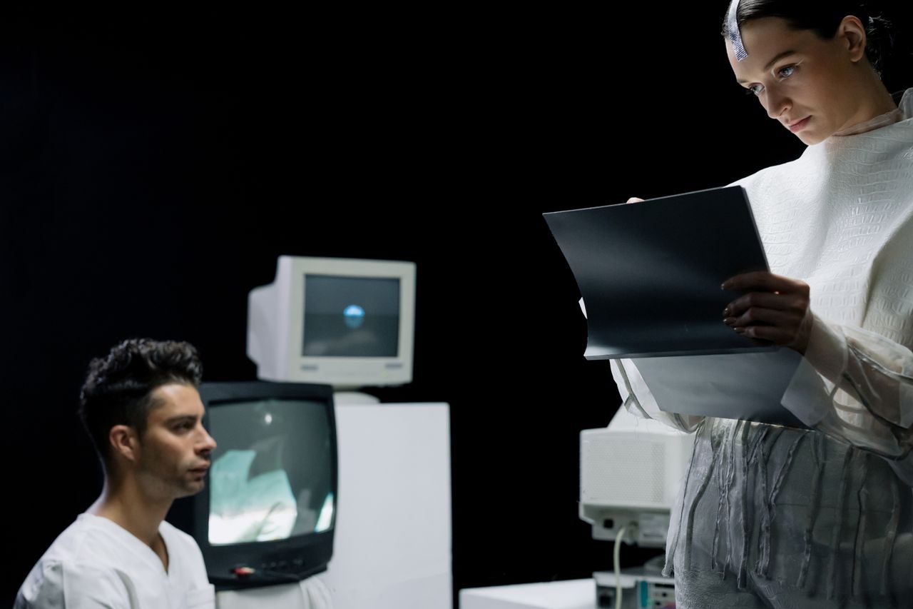 A futuristic lab with scientists reviewing a digital screen and data.