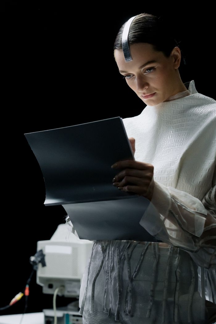 A futuristic scientist in a high-tech lab, analyzing data and taking notes on advanced equipment.